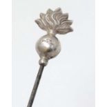 Hat Pin : A hat pin surmounted by a silver flaming grenade and marked C.H Sterling. Probably by