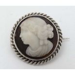 A carved hardstone cameo brooch with white metal mount. Approx 1" diameter  CONDITION: Please Note -