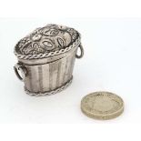 A Continental white metal miniature basket with hinged lid and fruit decoration hinging open to