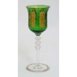 An  early - mid 20thC facet cut green glass wine glasses with gilded rim, scrolling foliate panels