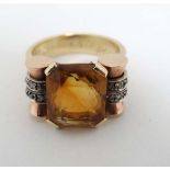 An unusual gold ring set with large central cetrine flanked by rose gold set with bands of chip