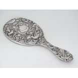 A Victorian silver hand mirror with embossed floral, scroll acanthus and bird decoration. Hallmarked