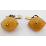 A pair of gilt metal cufflinks set with butterscotch coloured amber like decoration 
 CONDITION: