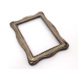 A shaped wooden photograph frame with applied silver surround. Hallmarked Birmingham 1919 maker