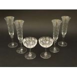 A set of 4 early 20thC glass champagne flutes with etched lily of the valley decoration. Approx 8