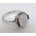 A 14ct white gold ring set with central moonstone flanked by 4 four blue stones  CONDITION: Please