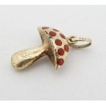 A 14ct (585) gold pendant / charm formed as a toadstool with red enamel decoration. Approx ¾”