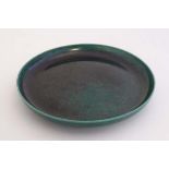 An early 20thC  green souffle glaze Ruskin Pottery plate , having impressed makers marks to base.