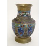 Cloisonné : An Japanese brass vase of baluster form with Cloisonne mask and shield decoration to