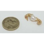 A 14k gold brooch formed as a seahorse set with a ruby stone to eye and blister pearl to body 1”