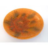 Royal Lancastrian : A Pilkington high fire plate decorated in mottled glazes in tones of orange,