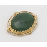 A gold brooch set with central jade cabochon. Marked 14k maker EB 1 1/2" wide  CONDITION: Please