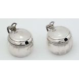 A pair of individual mustard pots with hinged lids and blue glass liners. Hallmarked Birmingham