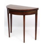 A Geo III mahogany demi-lune fold over card table with boxwood and ebony cross banding and