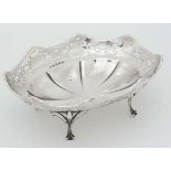 A silver bon bon dish with pierced decoration and standing on four outswept feet. Hallmarked