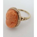 A gold ring set with a classical carved coral cameo. The cameo 5/8” high  CONDITION: Please