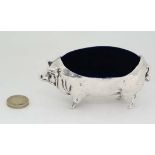 A late 20thC pin cushion / hat pin holder formed as a silver plate pig with cushion to back. 4 1/