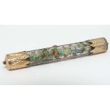 A gilt metal bar brooch with central cylindrical  clear tube containing various opal chips. Approx 2