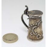An American Sterling silver miniature stein / lidded tankard with embossed decoration. Probably by
