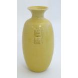 A yellow Chinese style Studio Pottery vase , decorated to sides with relief Chinese seal marks,