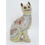 An early 20thC Mosanic Gallé style pottery cat, the pale green body having transfer decorated rug