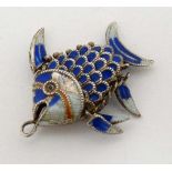 A white metal pendant / charm formed as a fish with articulated body and guilloche enamel