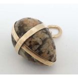 A pendant formed as an agate hardstone egg within a gilt metal mount. Approx 1” wide  CONDITION: