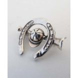 A .925 silver brooch formed as a horseshoe, hunting horn and hat. The whole  1” wide  CONDITION: