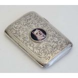 A silver cigarette case of shaped form with engraved acanthus scroll decoration. Hallmarked