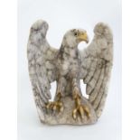 An early- mid 20th C carved marble sculpture of an eagle with glass eyes and wings half