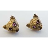 A pair of gold earrings formed as tiger / big cat heads set with ruby glass eyes.  CONDITION: Please