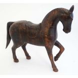 A carved wooden figure of a horse with saddle. 17 5/8'' high x 18'' long. CONDITION: Please