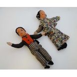 A Pair of early 20thC cloth dolls. Having printed faces and hand made clothing. The female doll