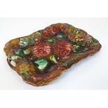 A 19thC two handled majolica bread plate / dish, decorated with red flowers on a brown and green