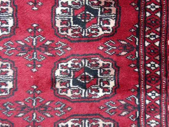 Rug / Carpet : a woollen Bokhara runner with 26 roundels to centre on a wine red back ground with - Image 4 of 6