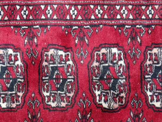 Rug / Carpet : a woollen Bokhara runner with 26 roundels to centre on a wine red back ground with - Image 5 of 6