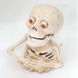 A skeleton money box  CONDITION: Please Note -  we do not make reference to the condition of lots