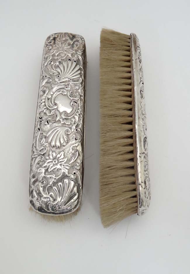 2 Victorian silver backed brushes with embossed decoration  CONDITION: Please Note -  we do not make