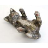 A pottery figure of a playful tabby cat with white paws. Indistinct painted monogram to base. Length