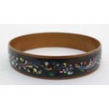 A copper bangle with polychrome enamelled decoration 3 1/4" wide x approx 3" diameter  CONDITION: