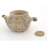 A small Japanese miniature teapot, having pierced side handle, decorated with brown geometric