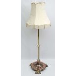 A brass and copper decorated adjustable standard lamp with circular base standing on 3 lobed