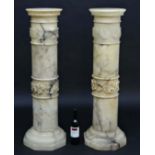 A pair of onyx / marble columns with octagonal bases, circular tops and bands of fruiting vine