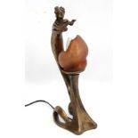 An Art Nouveau bronzed resin table lamp in the form of a figure and lily with glass shade. The whole