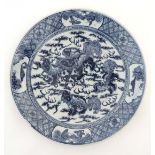 A Chinese blue and white plate decorated with Dogs of Fo around a pearl of wisdom, surrounded by