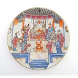 A large Chinese polychrome charger , hand painted with figures in an interior scene and stylised
