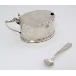 A silver mustard pot with blue glass liner, hallmarked London 1934 with jubilee mark. maker Edward