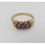 A 9ct gold ring set with three amethysts CONDITION: Please Note -  we do not make reference to the