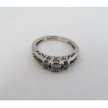 A 14ct white gold ring set with three diamonds to centre flanked by three diamonds to each