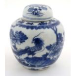 A Chinese blue and white ginger jar with lid, decorated with image of a Phoenix type bird on a rocky